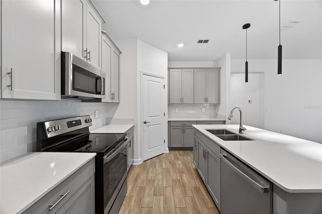 11128 Lore Way Orlando, FL 32832 - Photo 38 of 79 a kitchen with stainless steel appliances granite countertop a sink stove and refrigerator