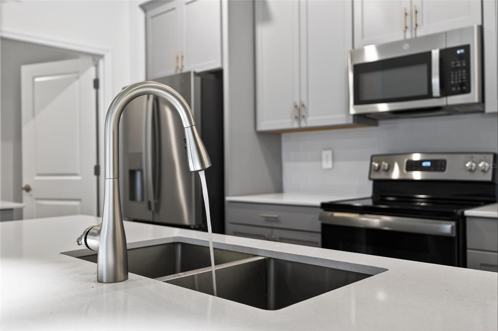 11128 Lore Way Orlando, FL 32832 - Photo 43 of 79 a kitchen with stainless steel appliances granite countertop a sink and a stove