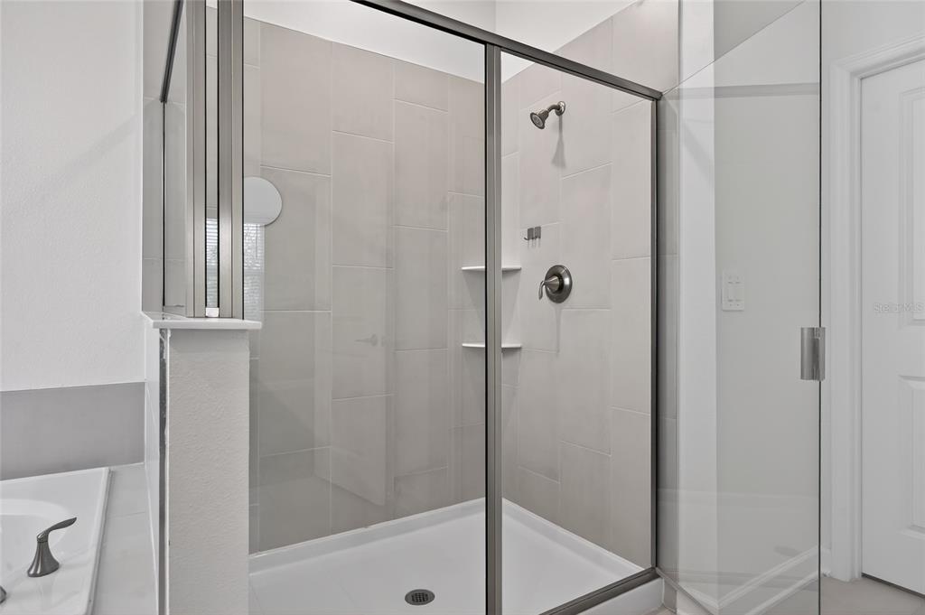 11128 Lore Way Orlando, FL 32832 - Photo 49 of 79 a bathroom with a glass shower door