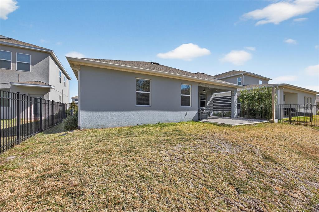 11128 Lore Way Orlando, FL 32832 - Photo 62 of 79 a backyard of a house with table and chairs under an umbrella