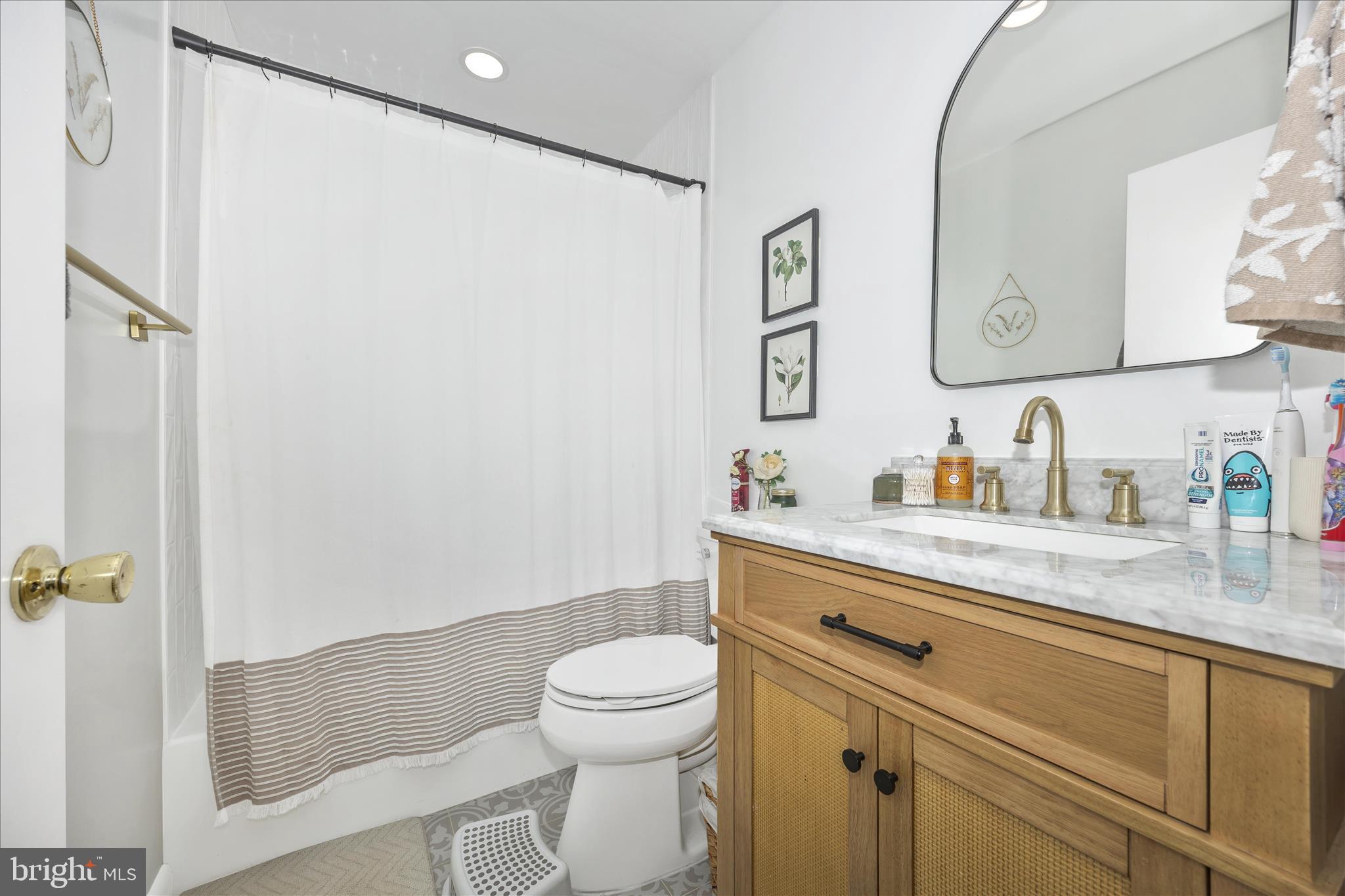 439 Center Street Frederick, MD 21701 - Photo 39 of 49 a bathroom with a granite countertop sink toilet and shower