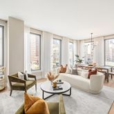 a living room with furniture and floor to ceiling windows
