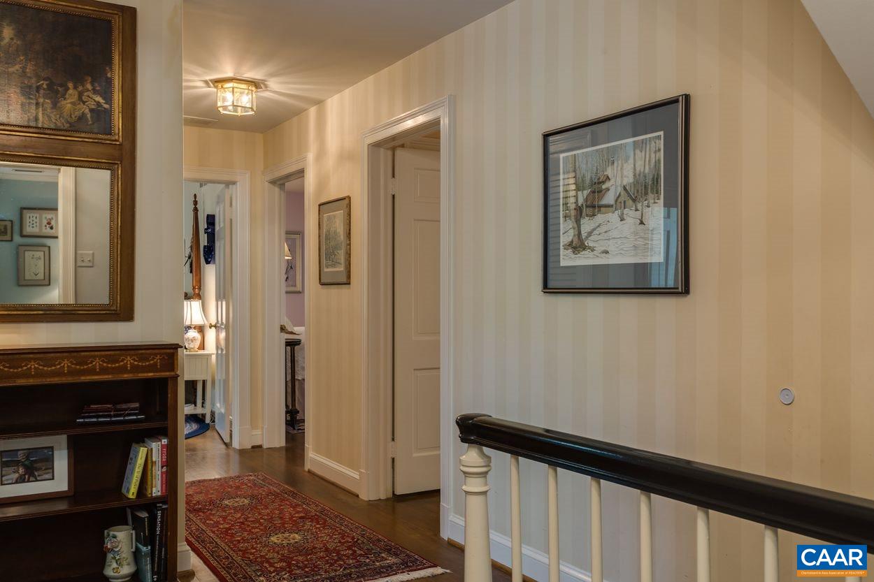 788 Tanglewood Road Charlottesville, VA 22901 - Photo 20 of 39 a view of a hallway with wooden floor and a fireplace