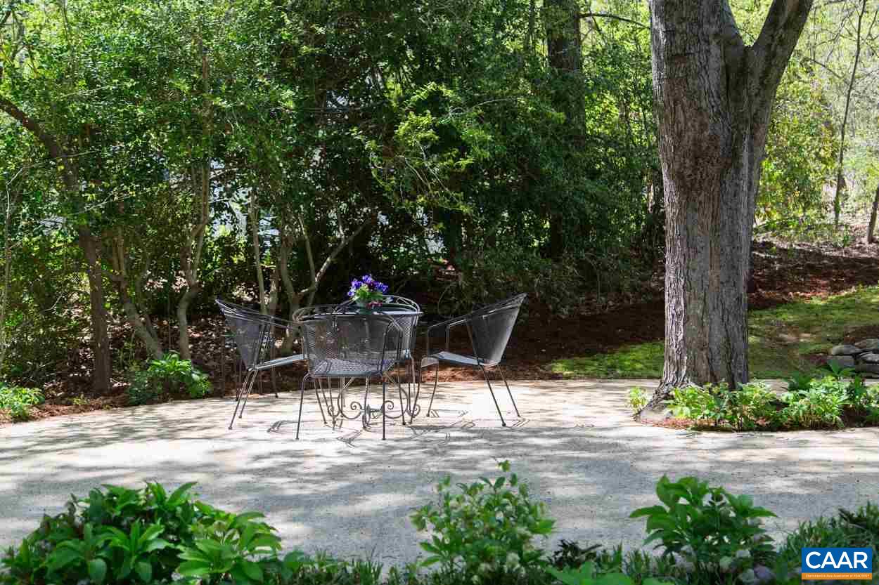 788 Tanglewood Road Charlottesville, VA 22901 - Photo 32 of 39 a backyard of a house with table and chairs under an large trees