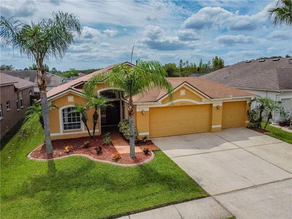 front view of house with a yard and potted plants