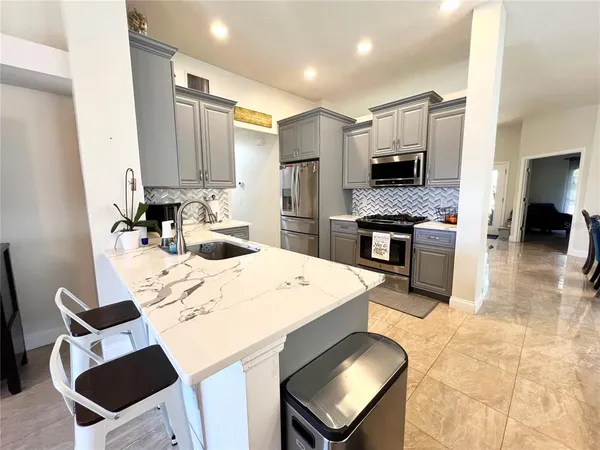 a kitchen with stainless steel appliances kitchen island granite countertop a sink and cabinets
