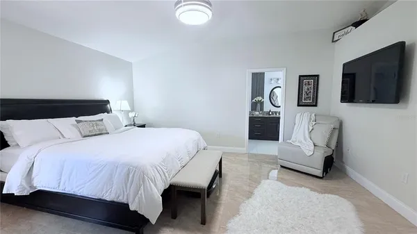 a bedroom with a bed and flat screen tv