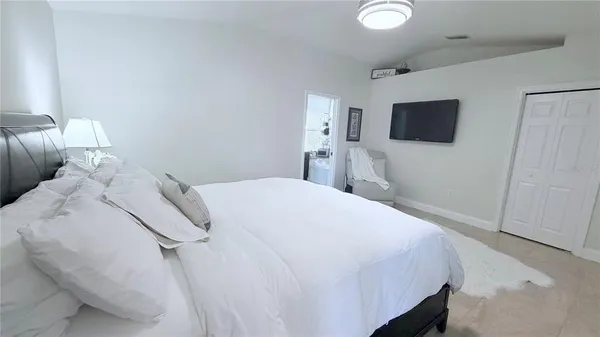 a bedroom with a bed and a flat screen tv