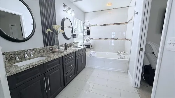a bathroom with a tub sink and mirror