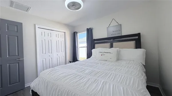 a large bed in a bedroom next to a window