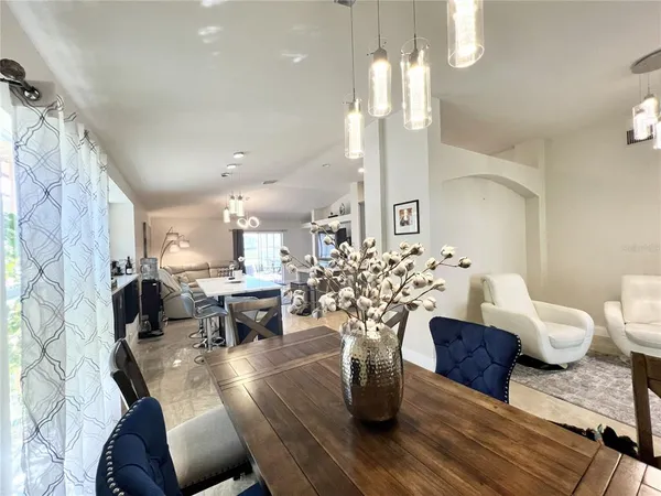 a living room with furniture a chandelier and a dining table