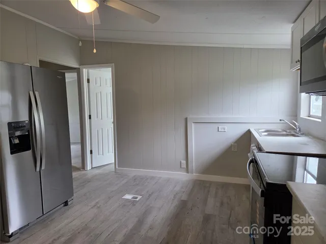 a view of a kitchen with a refrigerator cabinets and wooden floor