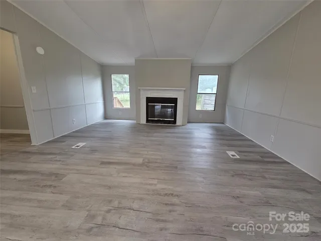 a view of an empty room with a fireplace and a window