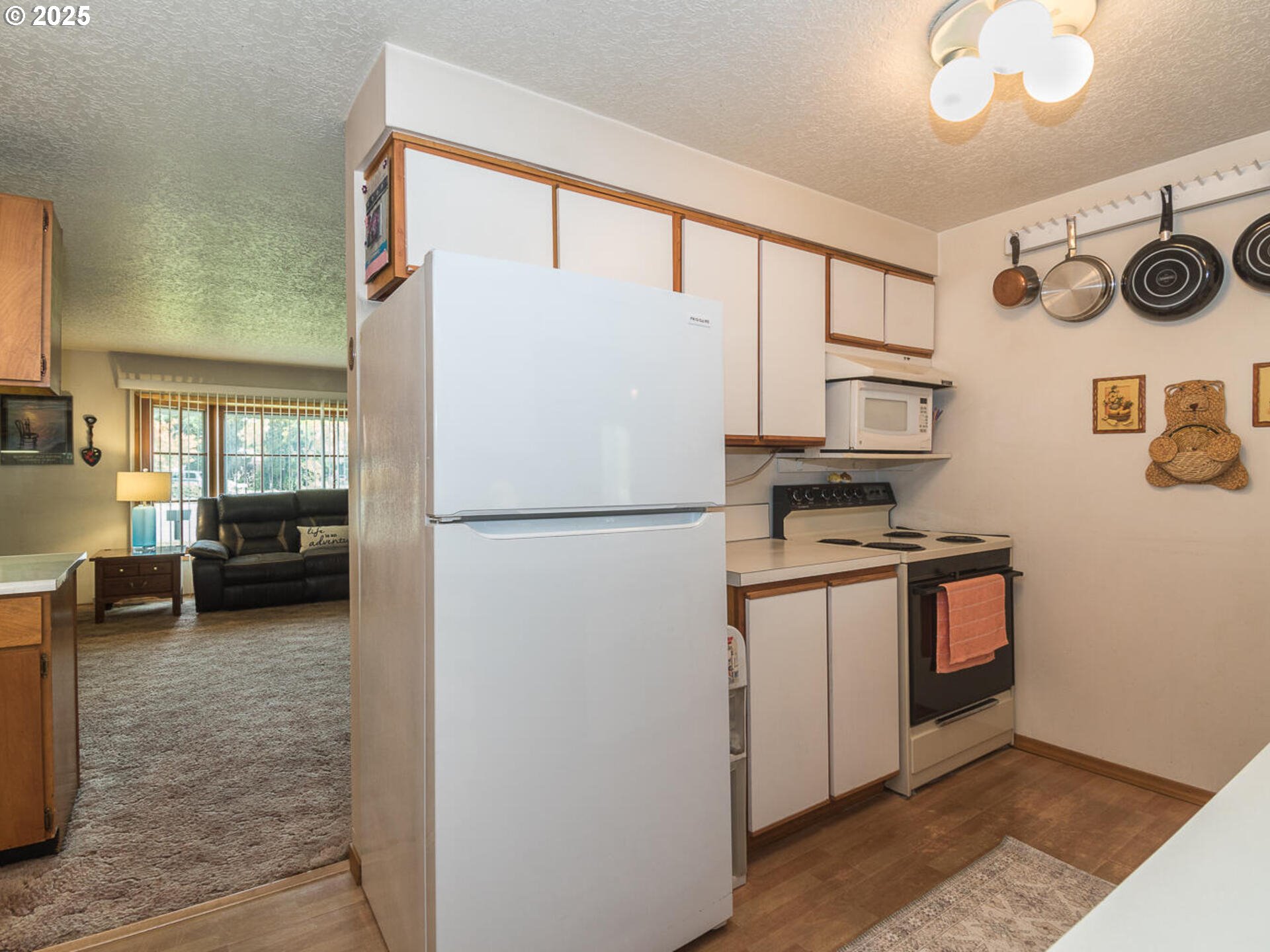 2068 Northeast Juniper Court Gresham, OR 97030 - Photo 13 of 42 a kitchen with stainless steel appliances granite countertop a refrigerator a stove and a sink with wooden floor