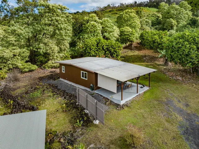 a view of a chair and table in backyard of the house