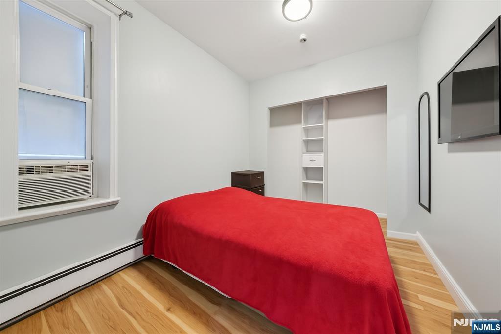 297 West Runyon Street Newark, NJ 07108 - Photo 11 of 14 a bedroom with a bed and a flat screen tv