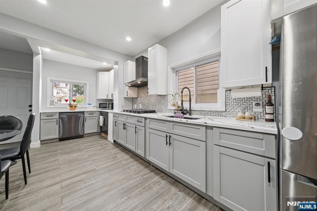 297 West Runyon Street Newark, NJ 07108 - Photo 2 of 14 a kitchen with white cabinets stainless steel appliances a sink and a window