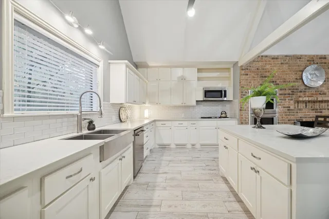 a large kitchen with a sink and cabinets