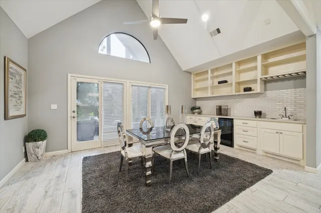 a dining room with wooden floor and a chandelier