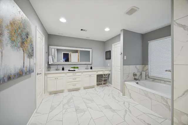 a bathroom with a granite countertop sink mirror and bathtub