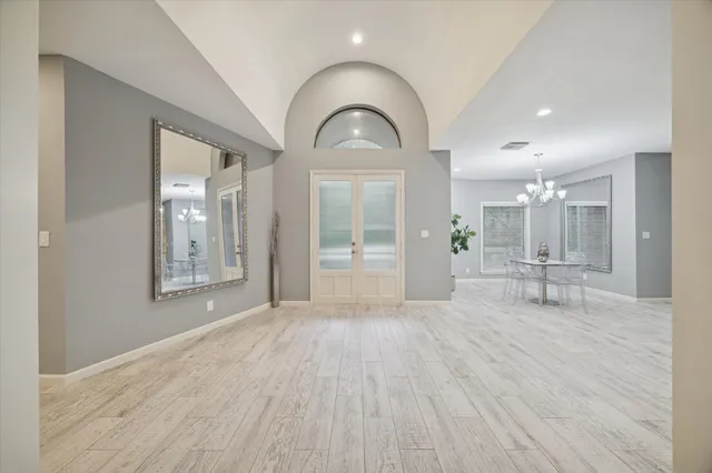 a view of empty room with wooden floor and glass door