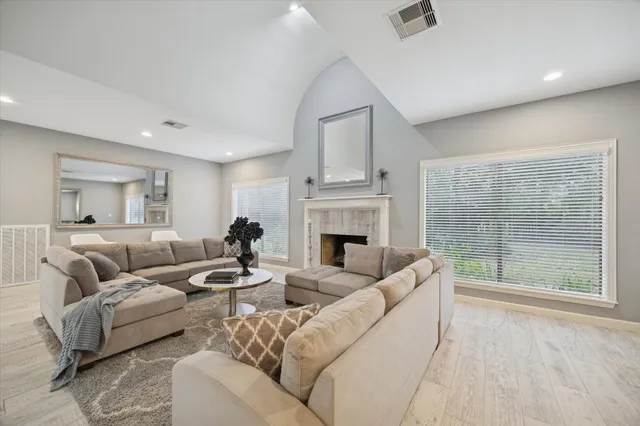 a living room with furniture a fireplace and a large window