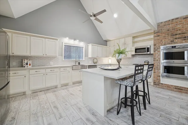 a kitchen with a table chairs microwave and cabinets