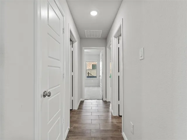 a view of a hallway with wooden floor
