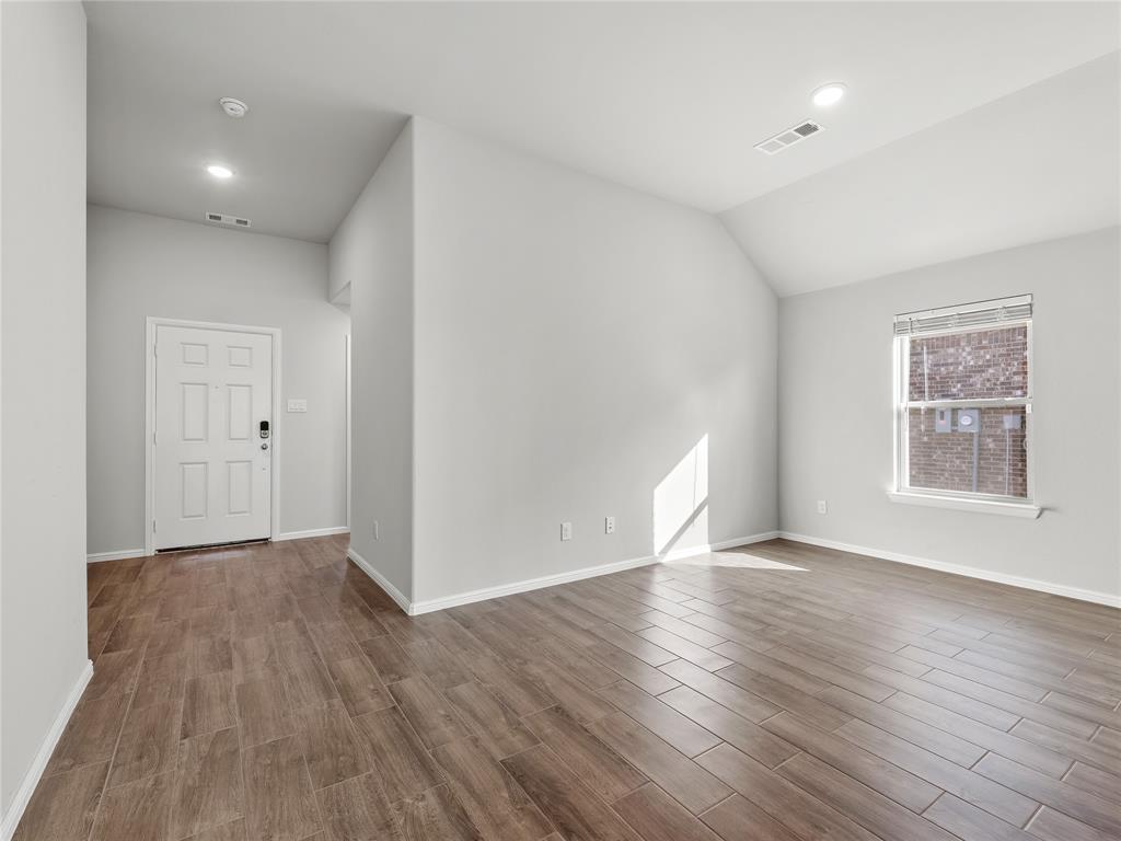 3301 Redbud Flower Trail Venus, TX 76084 - Photo 4 of 28 a view of an empty room with wooden floor and a window