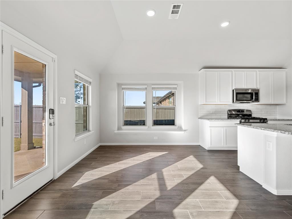 3301 Redbud Flower Trail Venus, TX 76084 - Photo 10 of 28 a kitchen with granite countertop a stove a sink and a refrigerator
