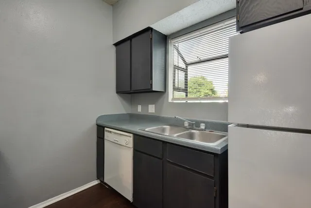 a bathroom with a granite countertop sink and a window