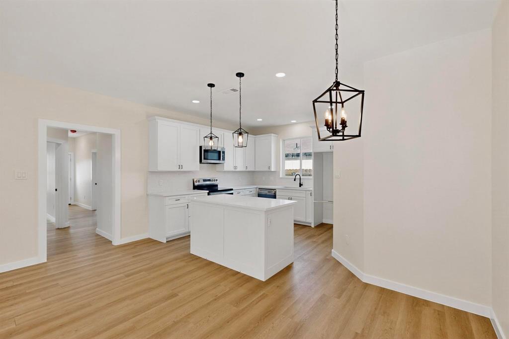 208 Rusk Street Rice, TX 75155 - Photo 12 of 27 a kitchen with stainless steel appliances granite countertop a sink a stove and a wooden floor