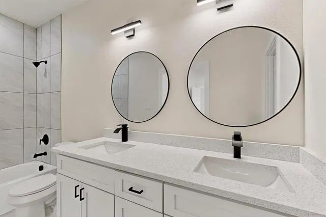 a bathroom with a sink a toilet and a mirror