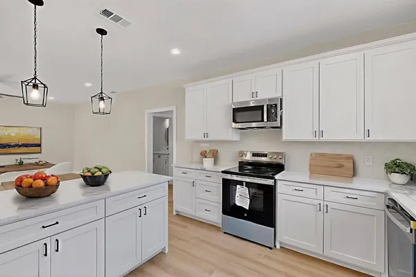 a kitchen with cabinets appliances and a counter top space