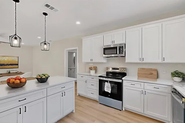 a kitchen with cabinets appliances and a counter top space