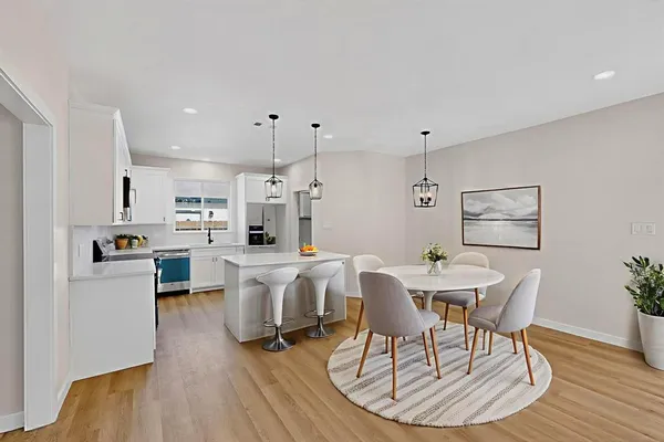 a view of a dining room with furniture wooden floor and a kitchen
