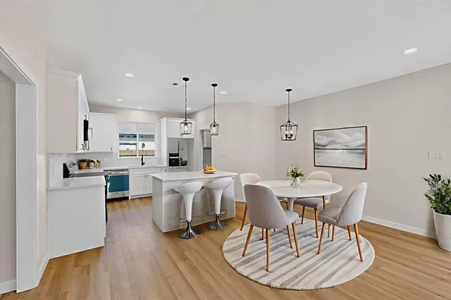 a view of a dining room with furniture wooden floor and a kitchen