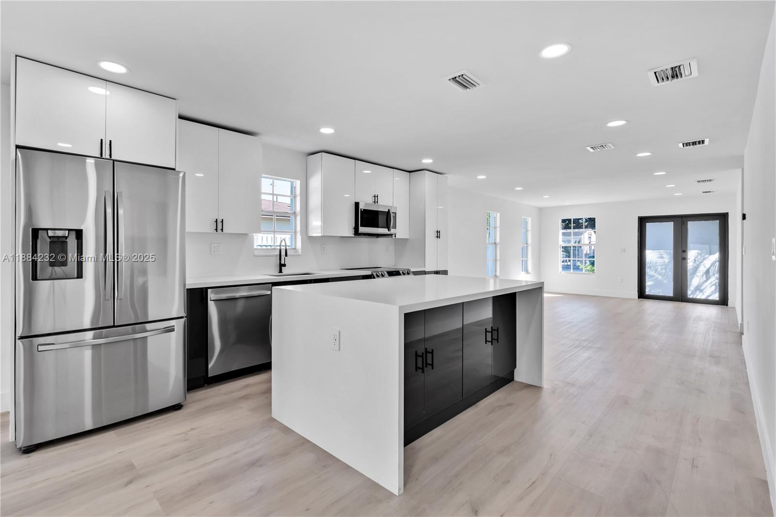 a kitchen with stainless steel appliances granite countertop a refrigerator a sink and a stove