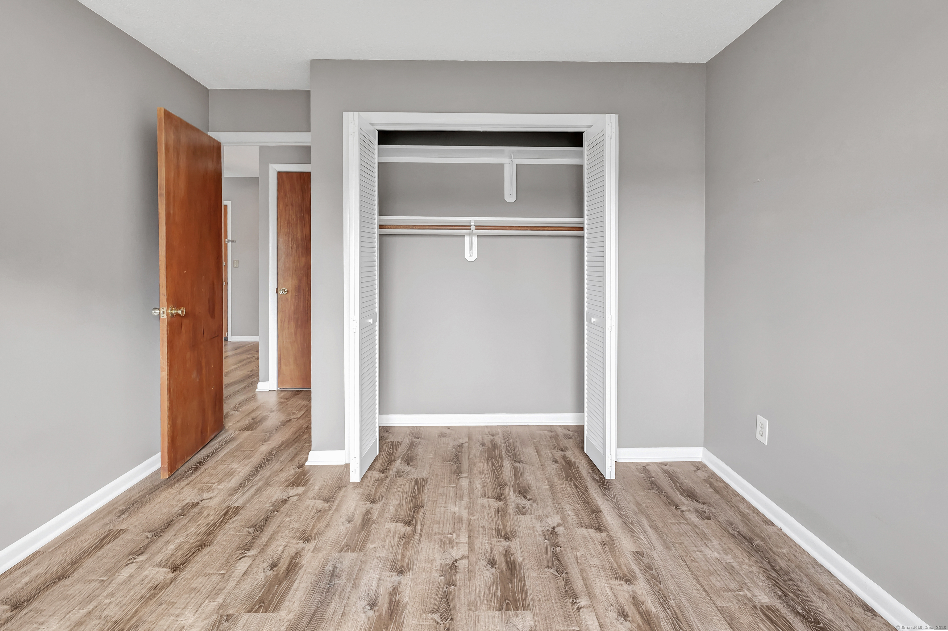 155 Short Beach Road, Unit 209 Stratford, CT 06615 - Photo 6 of 22 a view of an empty room with wooden floor and closet
