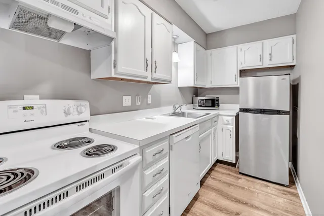 a kitchen with appliances a stove a sink and cabinets