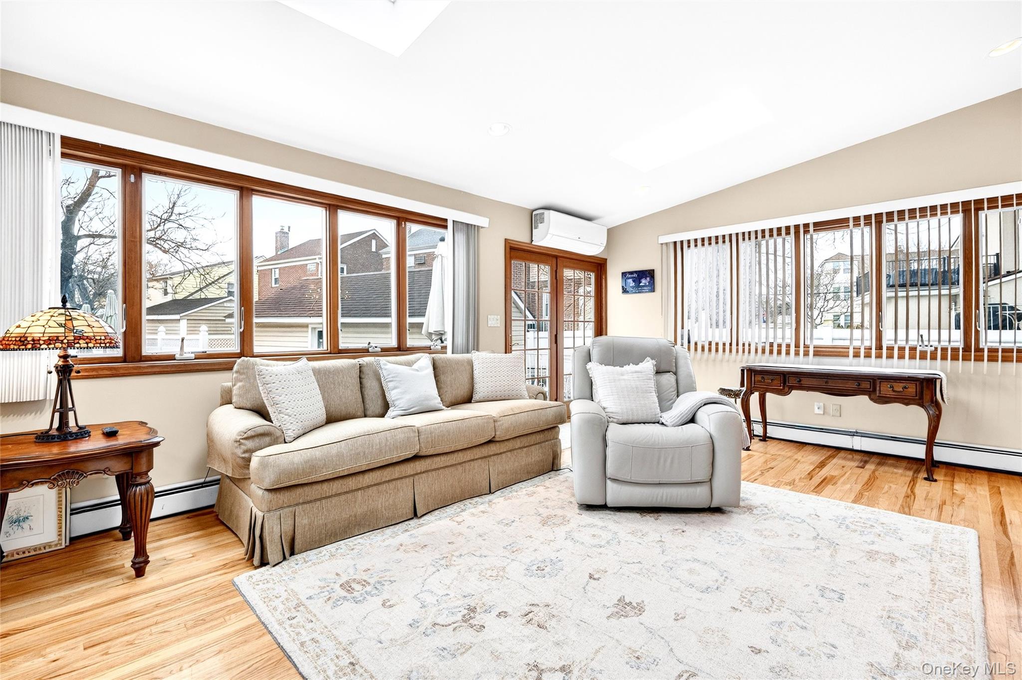 3334 Country Club Road Bronx, NY 10465 - Photo 25 of 49 Living room featuring lofted ceiling, light wood-style floors, healthy amount of natural light, and a wall mounted AC