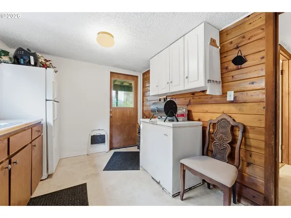 a kitchen with a refrigerator and white cabinets