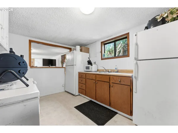 a kitchen with a refrigerator sink and wooden cabinets