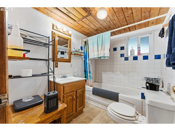 a bathroom with a sink toilet vanity and tub