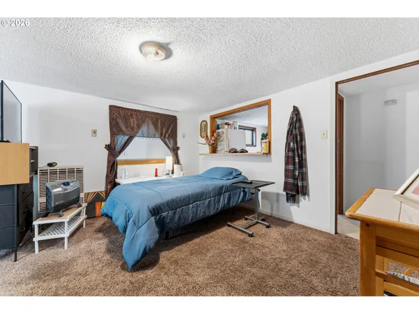a bedroom with a bed a mirror and lamp