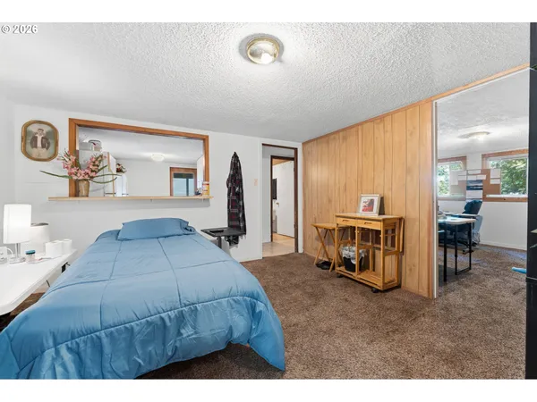 a living room with a bed furniture and a large mirror