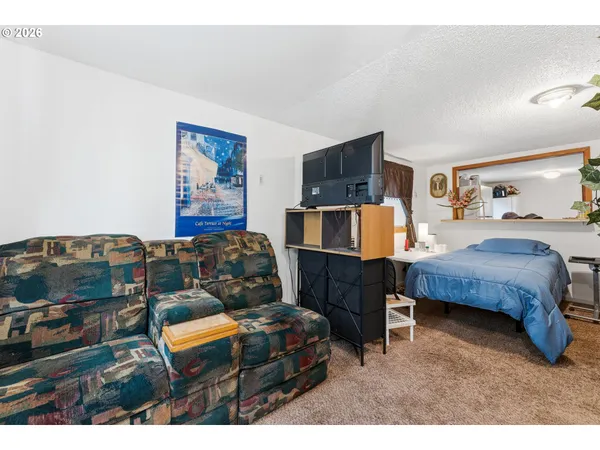 a bedroom with furniture and a flat screen tv