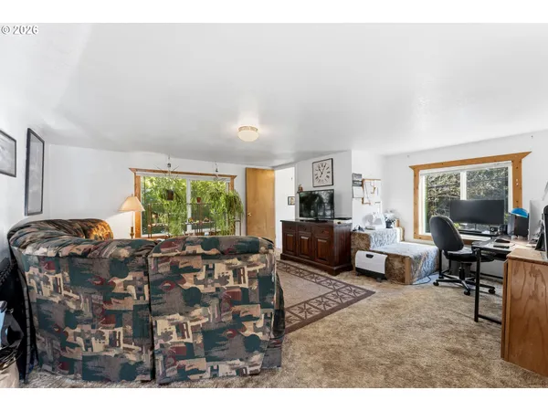 a living room with furniture large window and wooden floor