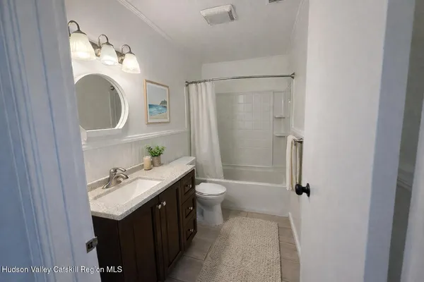 a bathroom with a toilet a sink a mirror and shower