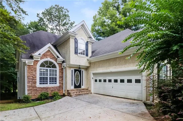 a view of a white house with large windows and a small yard